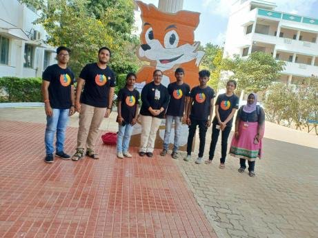 Group of people standing in front of large cartoon fox sculputer
