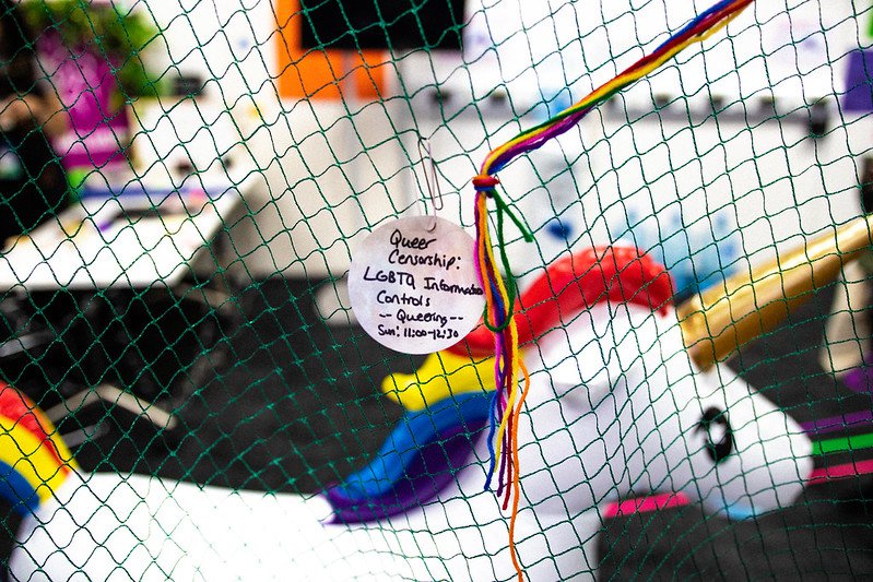 Queering MozFest Session Note on netting that hangs above unicorn blowup | Digital Inclusion work
