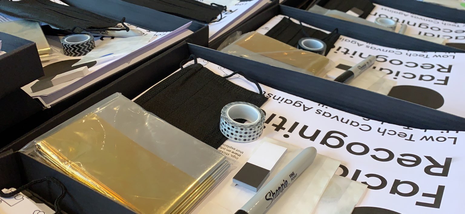 An image of materials laid out on a table - includes paper, canvas, tape, and a black marker