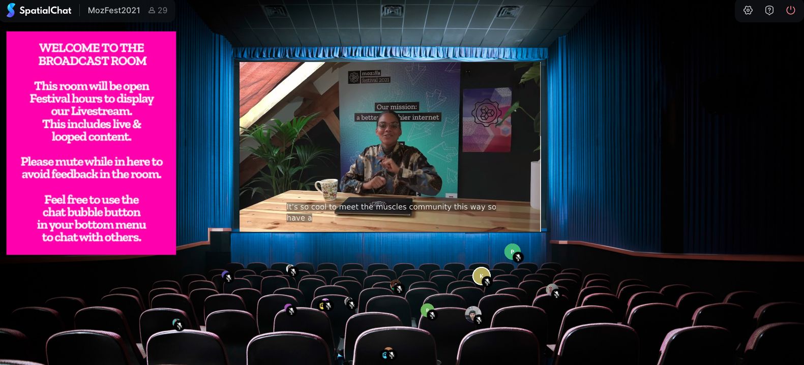 Virtual room that looks like a movie theater with a person on the big screen. A pink box is on the left hand side with instructions on how to use the room.