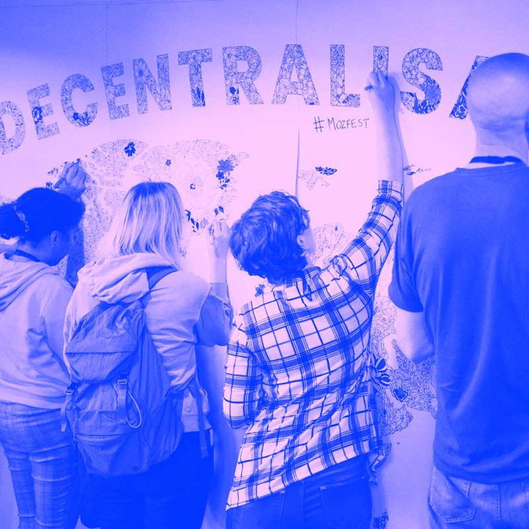 Group of participants at MozFest colouring in decentralisation poster