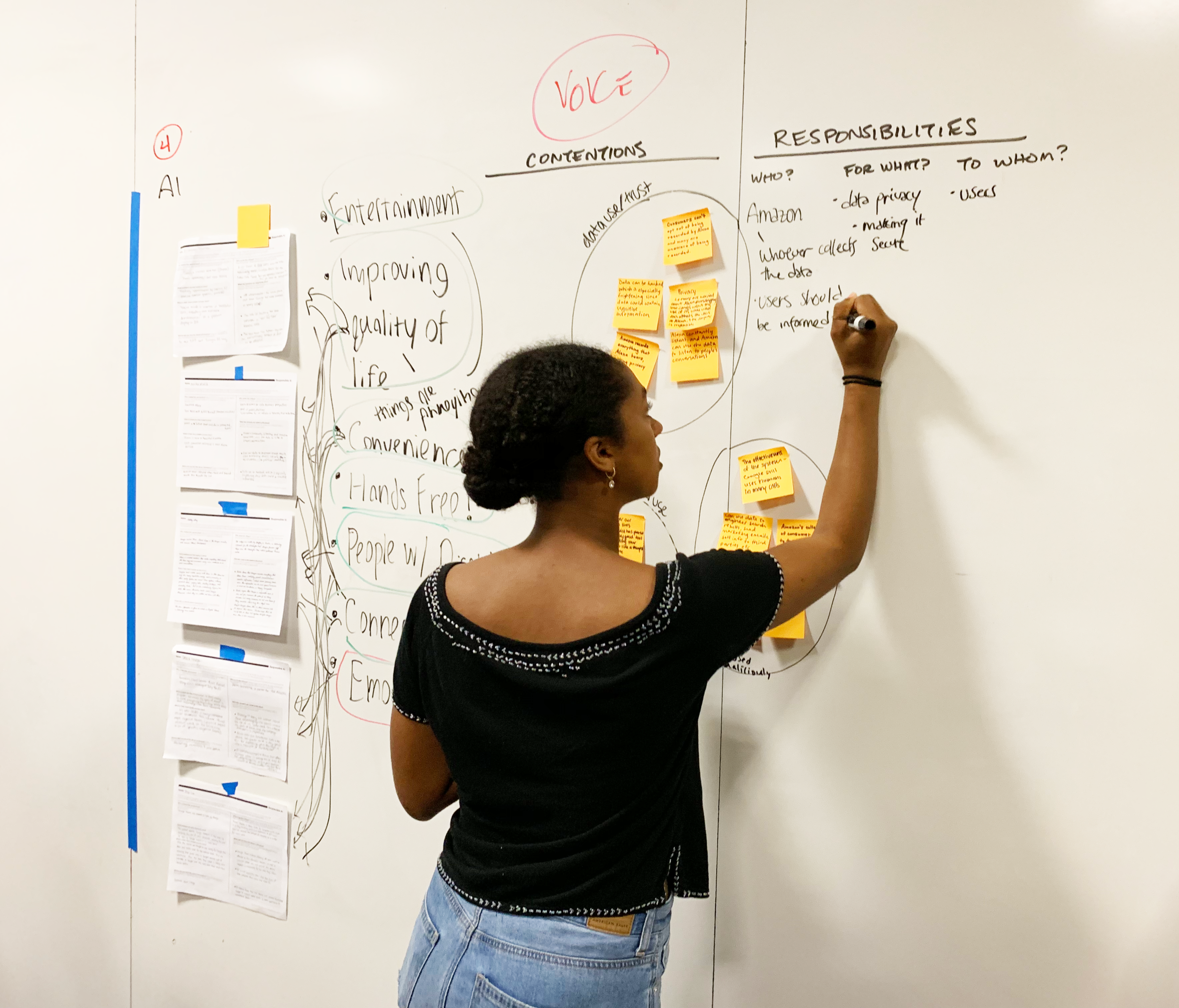 Woman writes on white board.